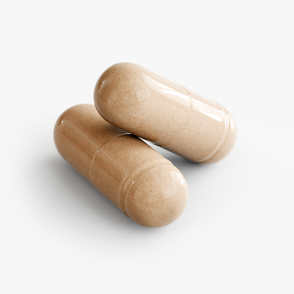 Two beige capsules of The Unruffled State Advanced Medicinal Mushroom Blend are stacked on a white surface, one resting atop the other.